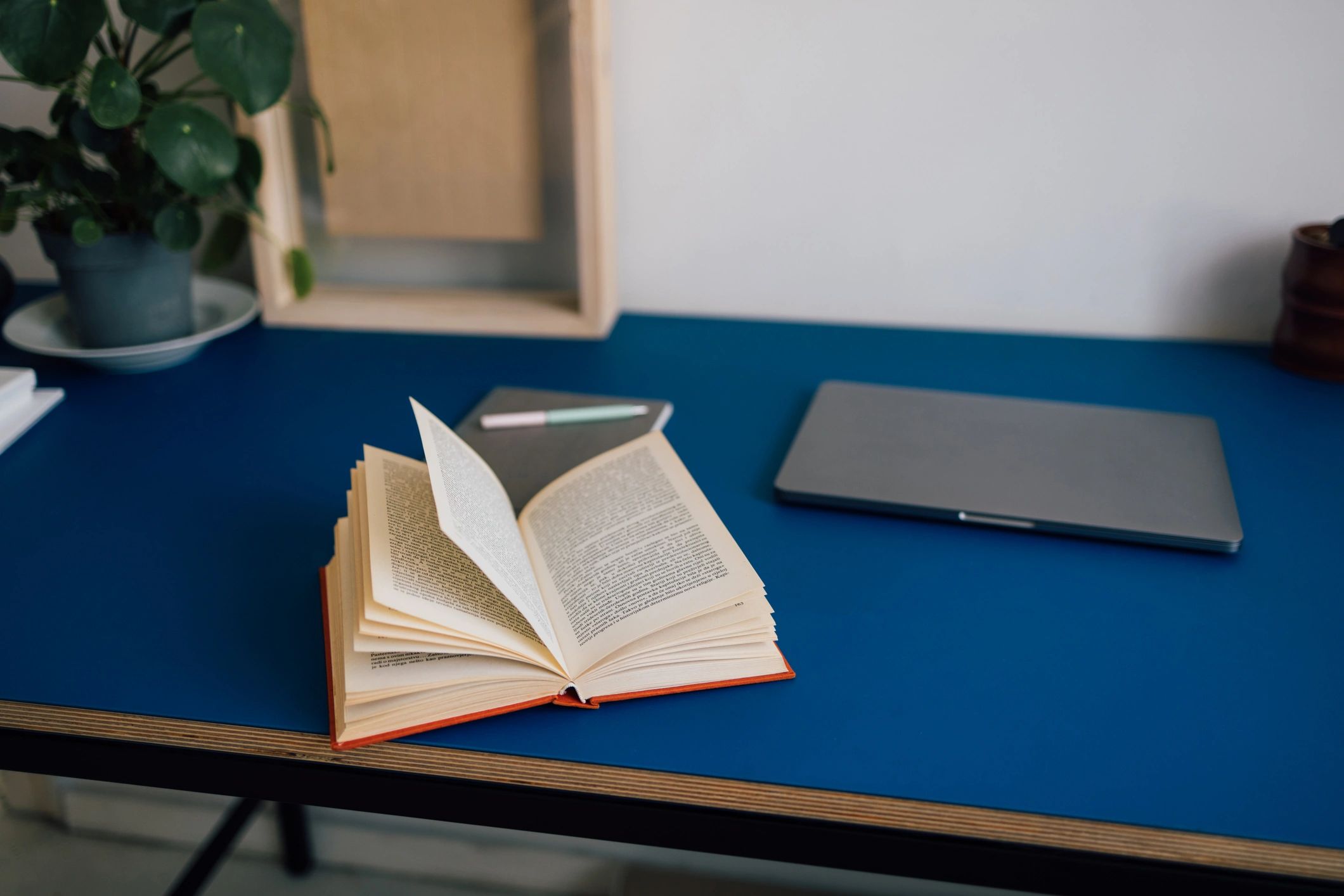 Laptop and open book on a study desk